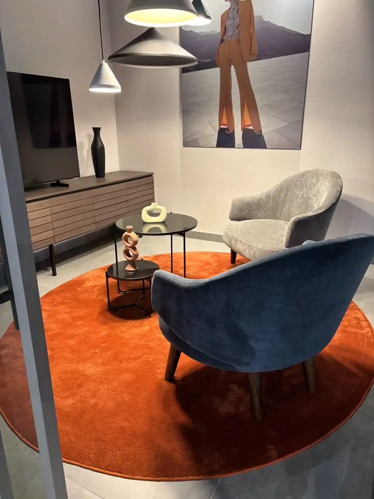 Sala de exhibición con alfombra circular naranja
