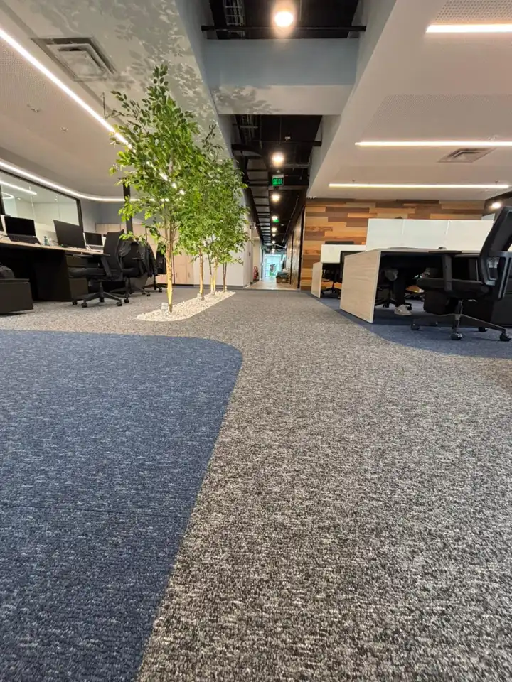 Oficina abierta con alfombra modular Flow gris y camino azul