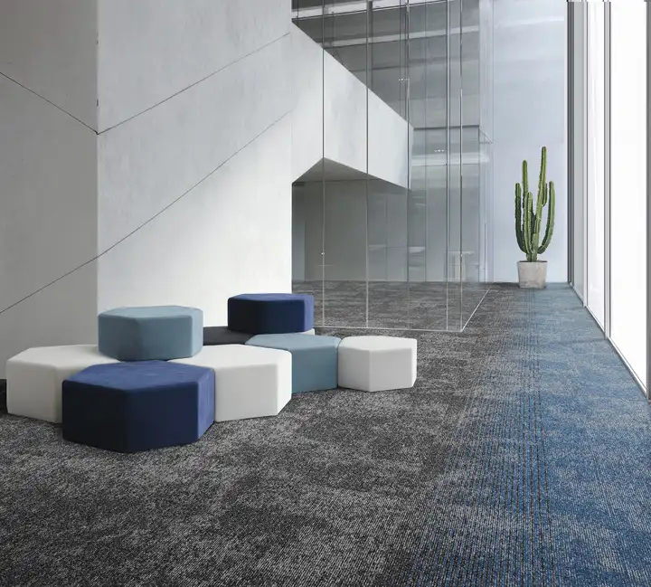 Ambiente de referencia de BLOQ con alfombra modular Glory 934, Eternity 533 y Glory 532 en difuminado de gris a azul