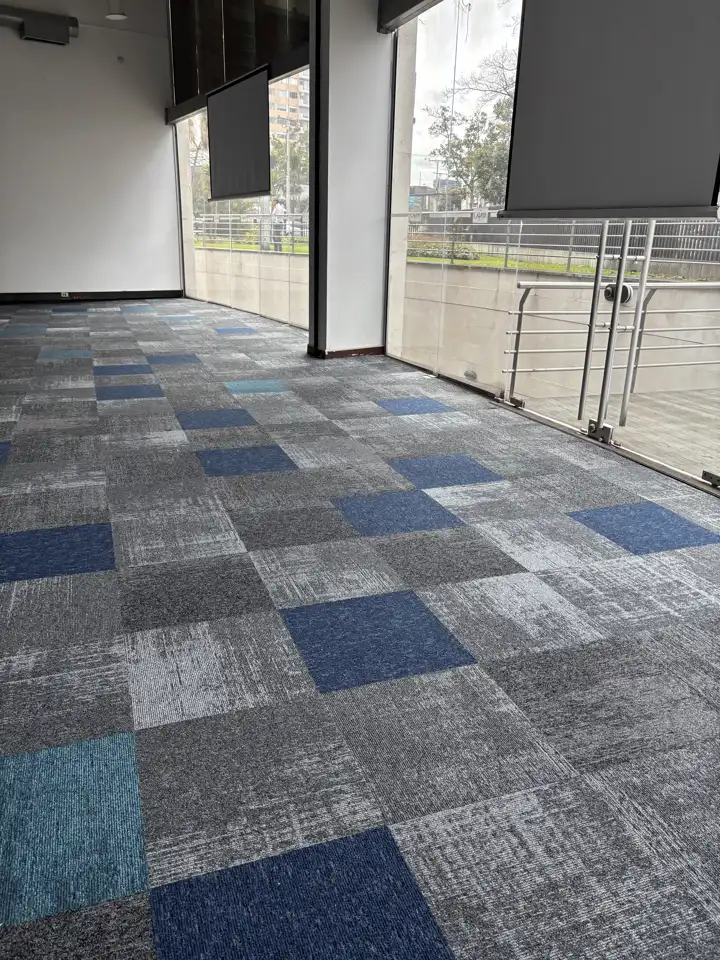 Aula de la Universidad Cafam con alfombra modular Sculpture con acentos azules