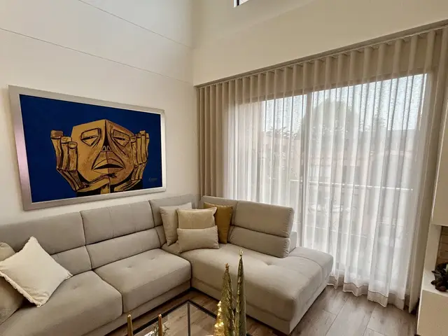 Sala con cortina de velo y cuadro azul
