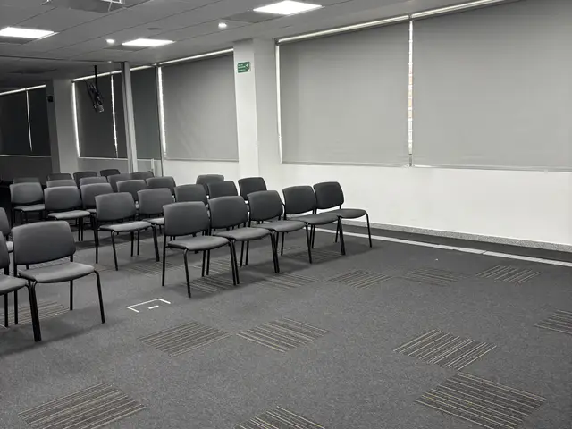 Auditorio con alfombra modular y cortinas enrollables